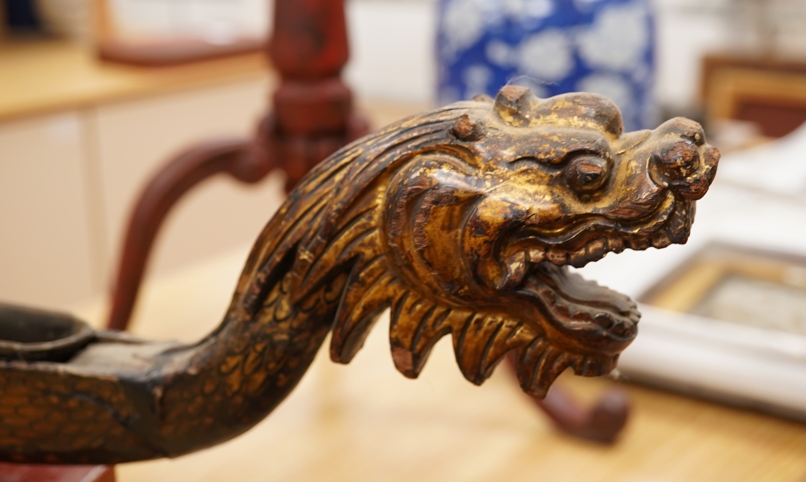A South East Asian gilt decorated black lacquer model 'dragon' boat on stand, 75cm